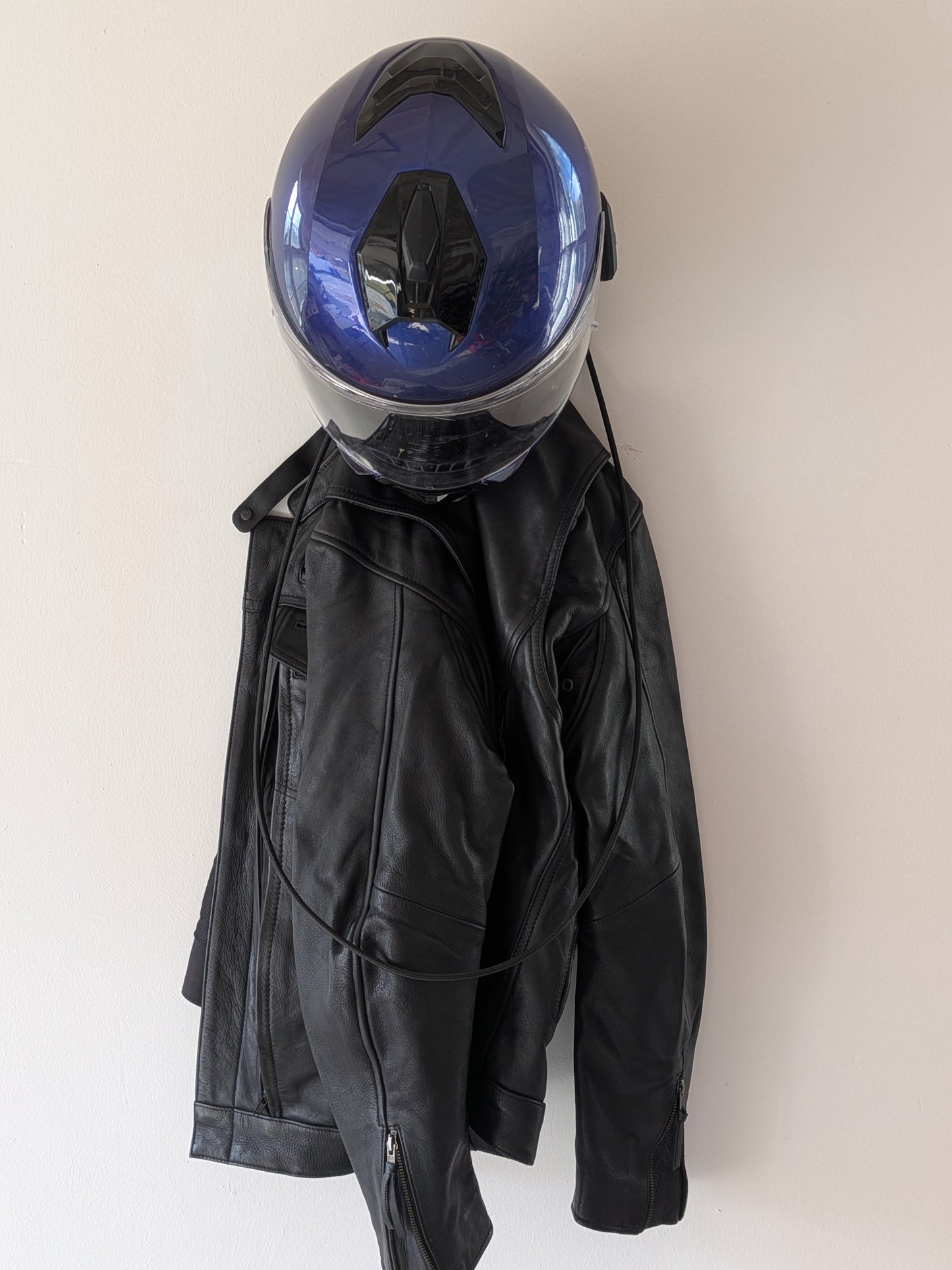 Black leather jacket with a blue helmet on a white background